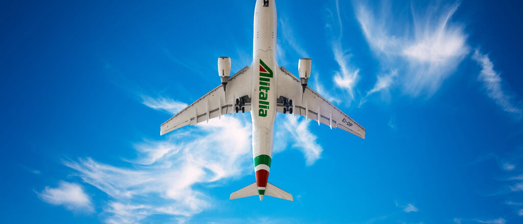 Alitalia Airbus A330 200 in new livery is flying in a blue sky